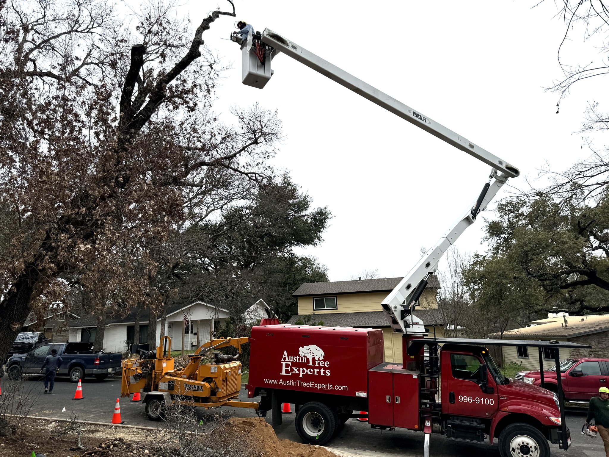 Bucket truck performing tree removal at a residential property in Austin TX